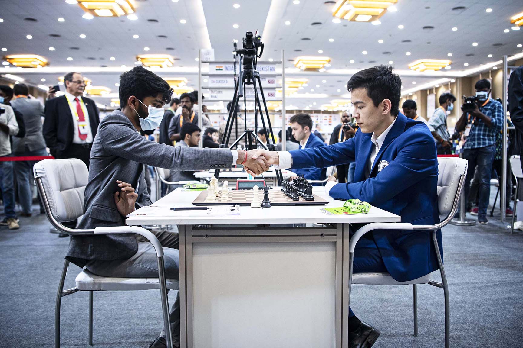 Gukesh shaking hands with Reigning World Rapid Chess Champion Uzbekistan's Nodirbek Abdusattorov before Round 10 of the 44th Chess Olympiad in Mamallapuram, Tamil Nadu on Monday. photo credit :  FIDE/Lennart Ootes & Stev Bonhage